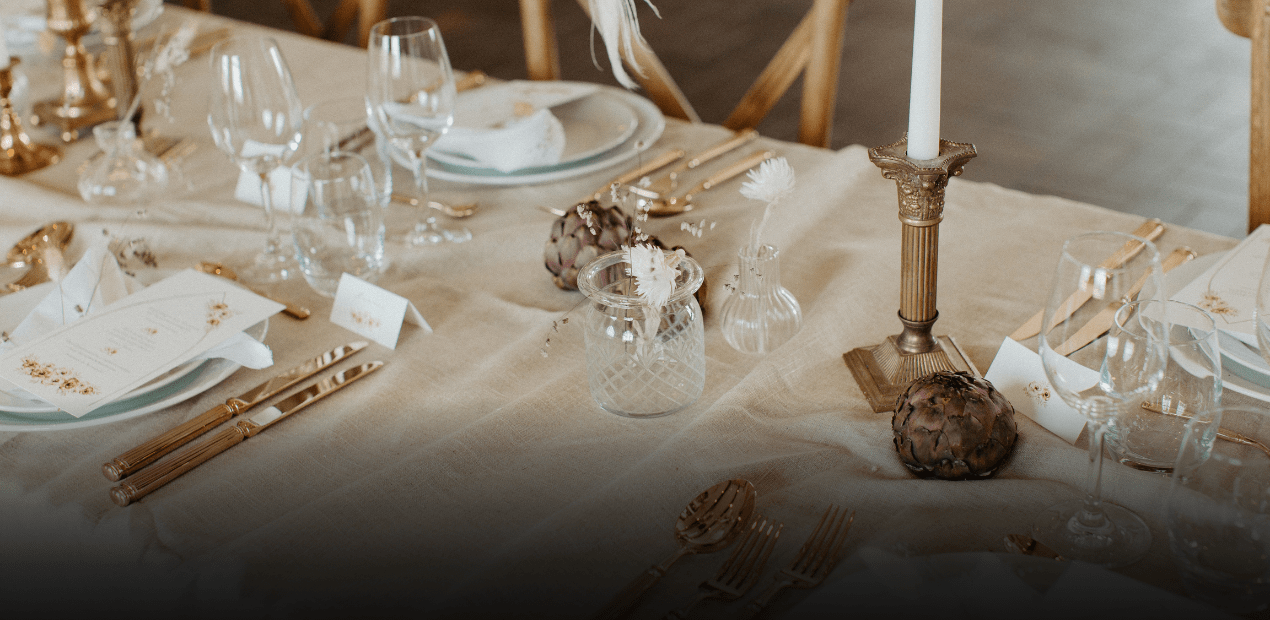 Elegant table setting with gold accents, candles, and decorative elements on a neutral background. - Flexonomic