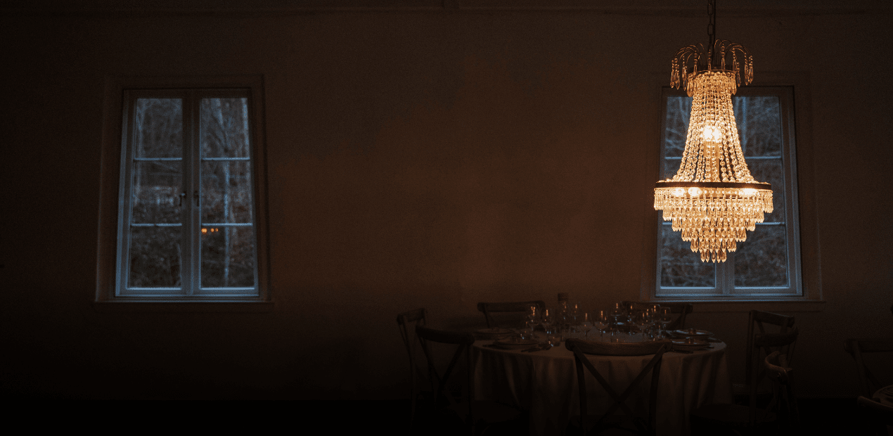 Dining room with a chandelier, table setting, and large windows. - Flexonomic